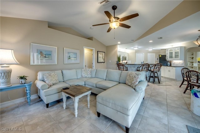 living room with ceiling fan, light tile patterned floors, and lofted ceiling