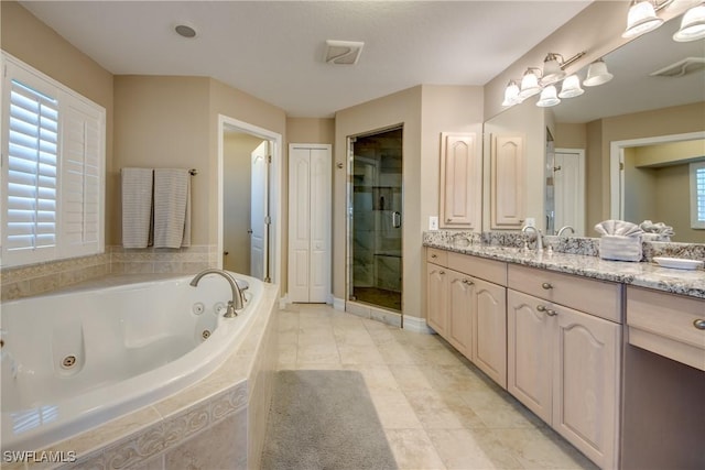 bathroom with vanity and shower with separate bathtub