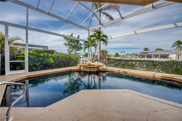 view of swimming pool with glass enclosure and a patio