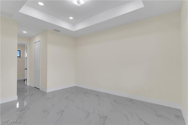 unfurnished room with a raised ceiling