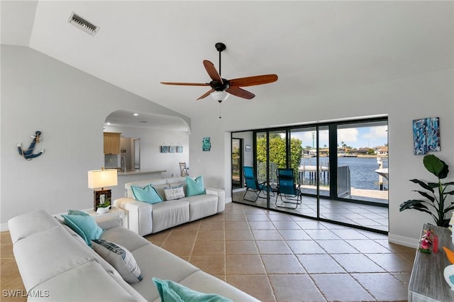 living room with vaulted ceiling, a water view, light tile patterned floors, ceiling fan, and sink