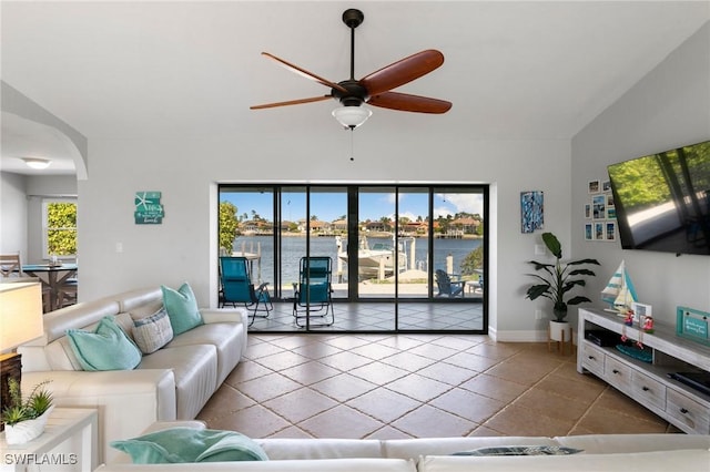 living room with ceiling fan, lofted ceiling, and tile patterned floors