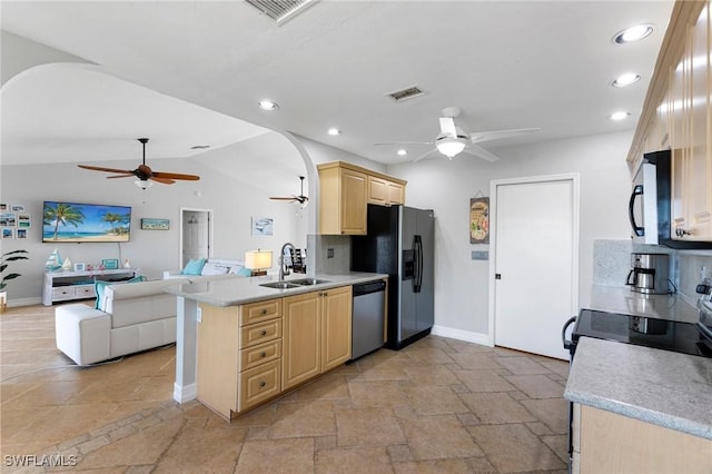 kitchen featuring sink, lofted ceiling, light brown cabinets, kitchen peninsula, and appliances with stainless steel finishes