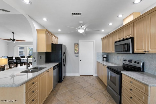 kitchen featuring light brown cabinetry, appliances with stainless steel finishes, decorative backsplash, and sink