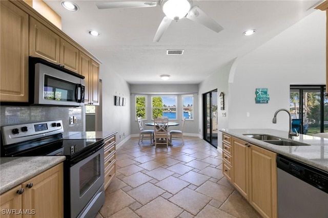 kitchen featuring sink, ceiling fan, backsplash, and appliances with stainless steel finishes