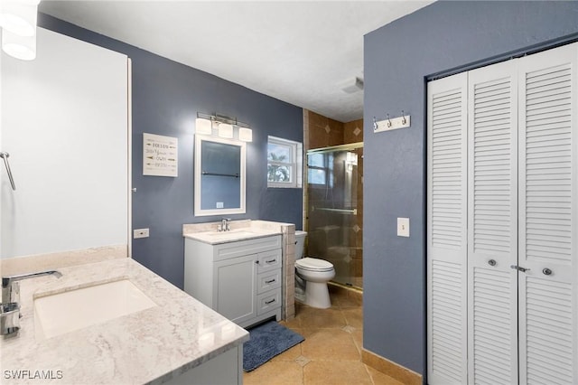 bathroom featuring a shower with door, tile patterned flooring, vanity, and toilet