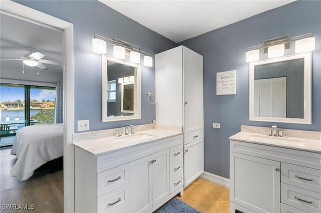 bathroom featuring a water view, tile patterned flooring, ceiling fan, and vanity