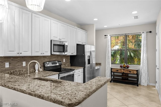 kitchen with decorative backsplash, white cabinetry, kitchen peninsula, and appliances with stainless steel finishes