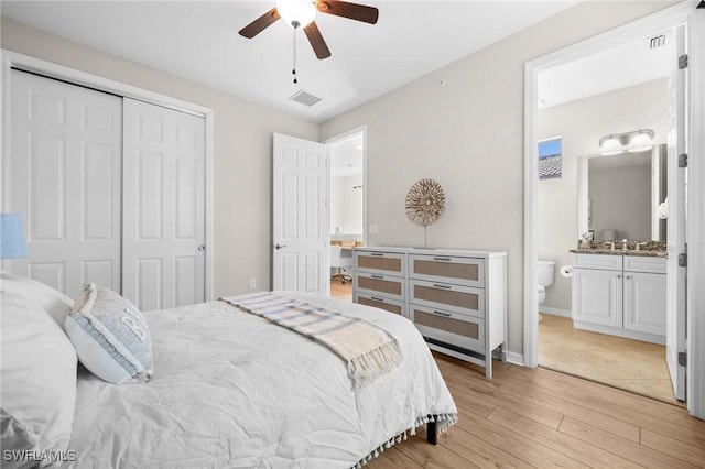 bedroom with ceiling fan, sink, ensuite bathroom, light hardwood / wood-style floors, and a closet