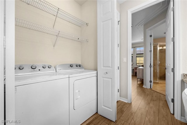 washroom with light wood-type flooring and separate washer and dryer