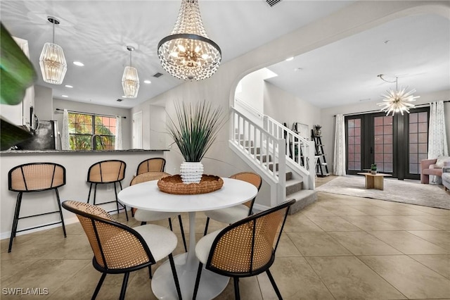 dining space with a notable chandelier, light tile patterned floors, sink, and french doors