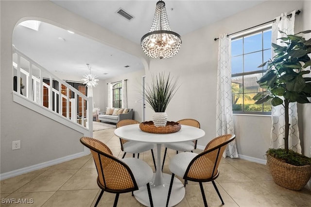 dining area with light tile patterned flooring and a notable chandelier