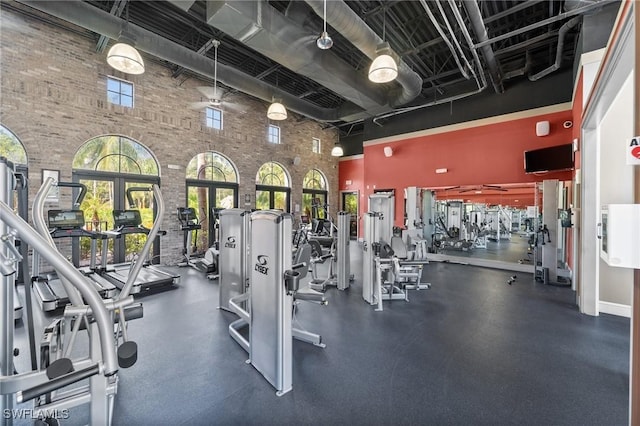 workout area with brick wall and a high ceiling