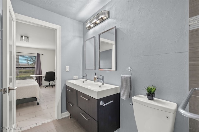 bathroom with tile patterned flooring, vanity, and toilet