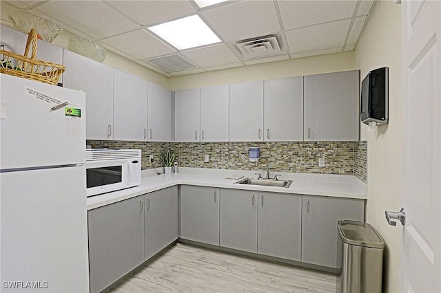 13268 Whitehaven Ln Unit 102, Fort Myers, FL 33966 - kitchen featuring white appliances, a sink, gray cabinets, a paneled ceiling, and decorative backsplash