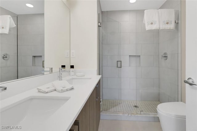 bathroom with tile patterned flooring, vanity, an enclosed shower, and toilet