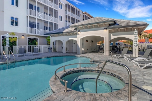 view of swimming pool featuring a community hot tub and a patio