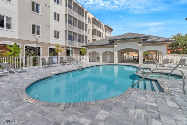 view of pool featuring a patio area and a community hot tub