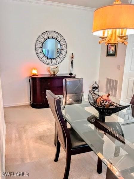 dining space featuring light colored carpet and crown molding