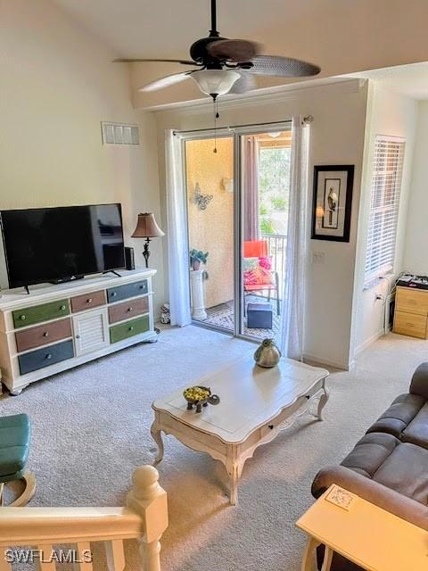 carpeted living room with ceiling fan