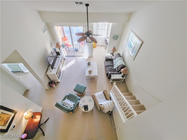 living room featuring ceiling fan and a high ceiling