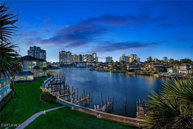 dock area featuring a water view, a city view, and a yard