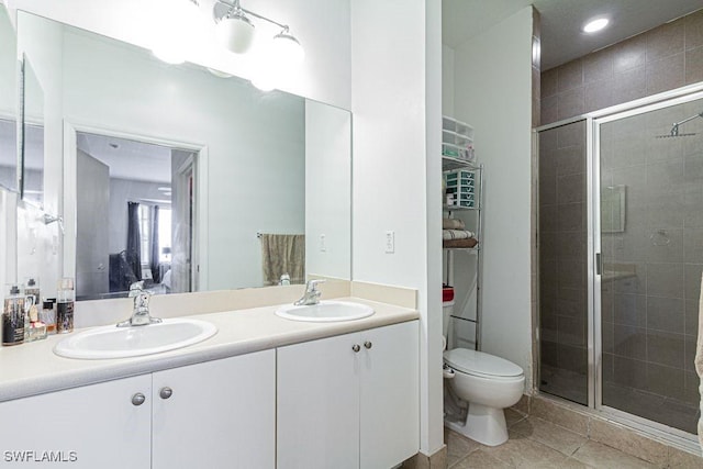 bathroom with tile patterned floors, vanity, toilet, and an enclosed shower