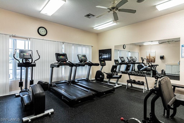 gym featuring ceiling fan and a textured ceiling