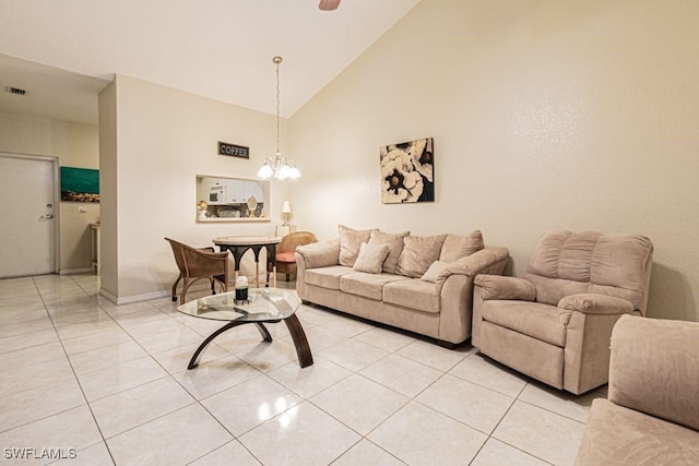 tiled living room featuring an inviting chandelier and high vaulted ceiling