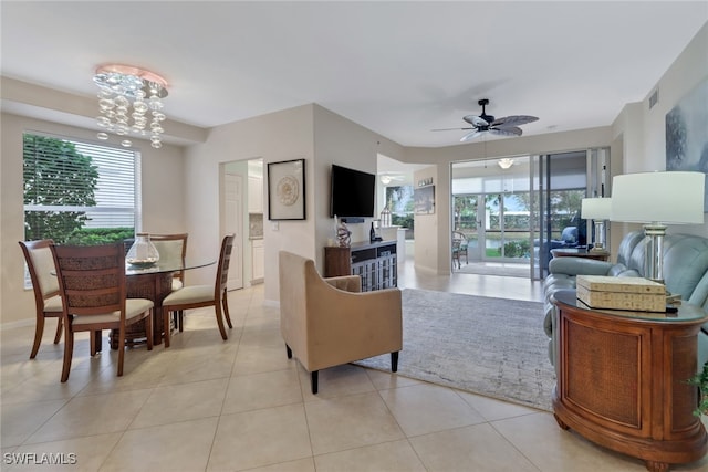 tiled living room with a healthy amount of sunlight and ceiling fan with notable chandelier