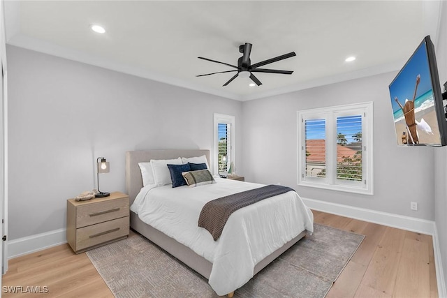 bedroom with ceiling fan, crown molding, light hardwood / wood-style flooring, and multiple windows