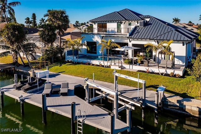 view of dock featuring a swimming pool, a balcony, a patio, and a water view