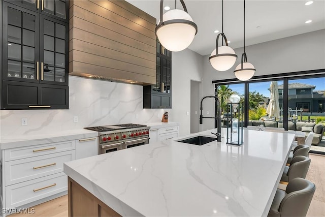 1631 Galleon Ct, Marco Island, FL 34145 - kitchen with range with two ovens, light stone countertops, decorative backsplash, recessed lighting, and wall chimney exhaust hood