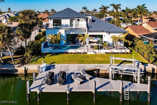 1631 Galleon Ct, Marco Island, FL 34145 - rear view of property with a water view, a standing seam roof, boat lift, a balcony, and a lawn