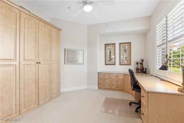 home office featuring baseboards, a ceiling fan, and light colored carpet