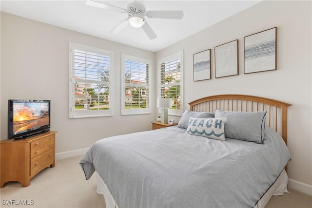 bedroom with light carpet, a ceiling fan, and baseboards