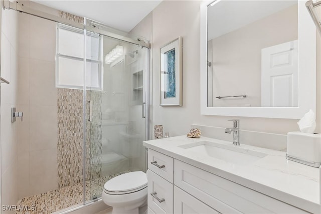 full bathroom with toilet, a shower stall, and vanity