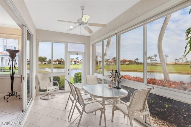 sunroom / solarium featuring ceiling fan and a water view