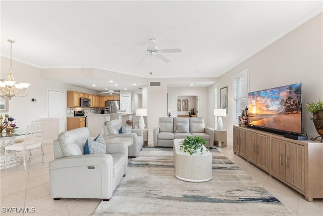 living room featuring ornamental molding, ceiling fan with notable chandelier, visible vents, and light tile patterned flooring