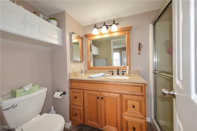 bathroom with walk in shower, vanity, and toilet