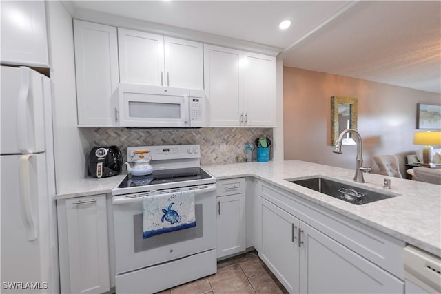 kitchen with white cabinets, decorative backsplash, sink, and white appliances