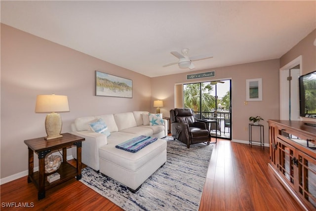 living room with ceiling fan and dark hardwood / wood-style flooring