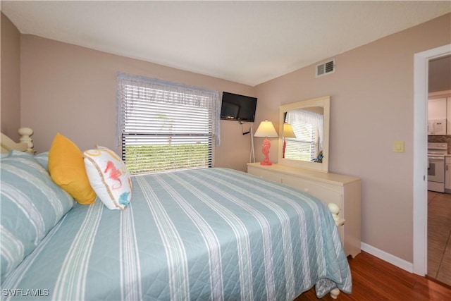 bedroom with hardwood / wood-style flooring and ensuite bathroom