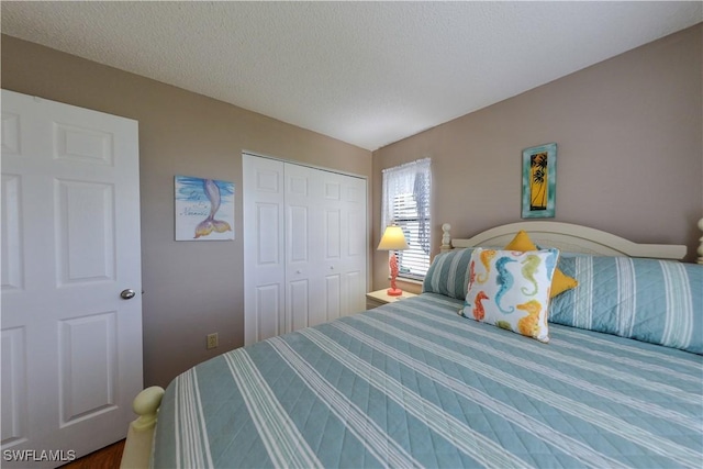 bedroom with a textured ceiling and a closet