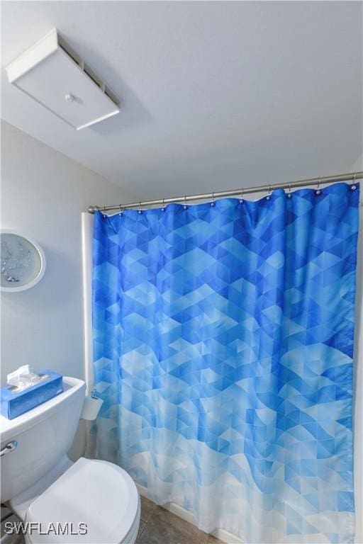 bathroom with toilet, tile patterned floors, and a shower with shower curtain