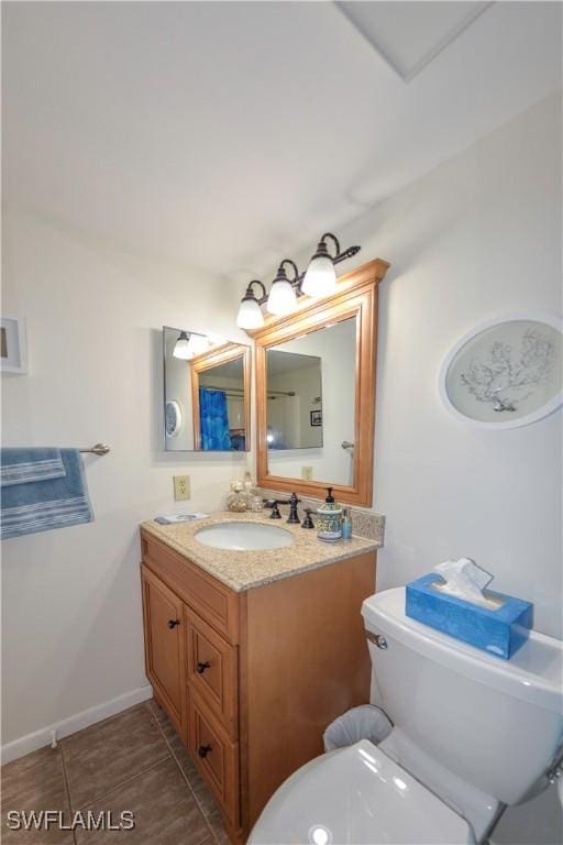 bathroom featuring toilet, vanity, and tile patterned floors