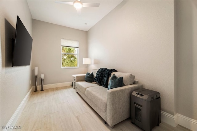 living room featuring ceiling fan, light hardwood / wood-style flooring, and vaulted ceiling