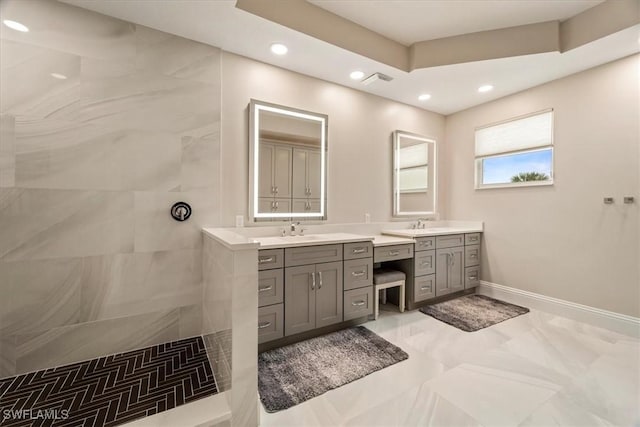 bathroom featuring tiled shower and vanity