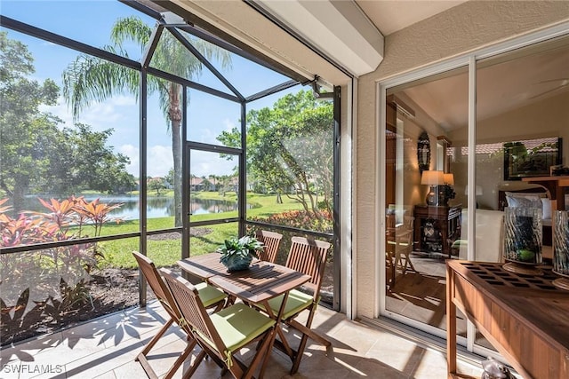 sunroom / solarium featuring a water view and lofted ceiling