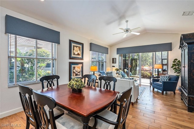 dining space with ceiling fan, vaulted ceiling, and light hardwood / wood-style flooring